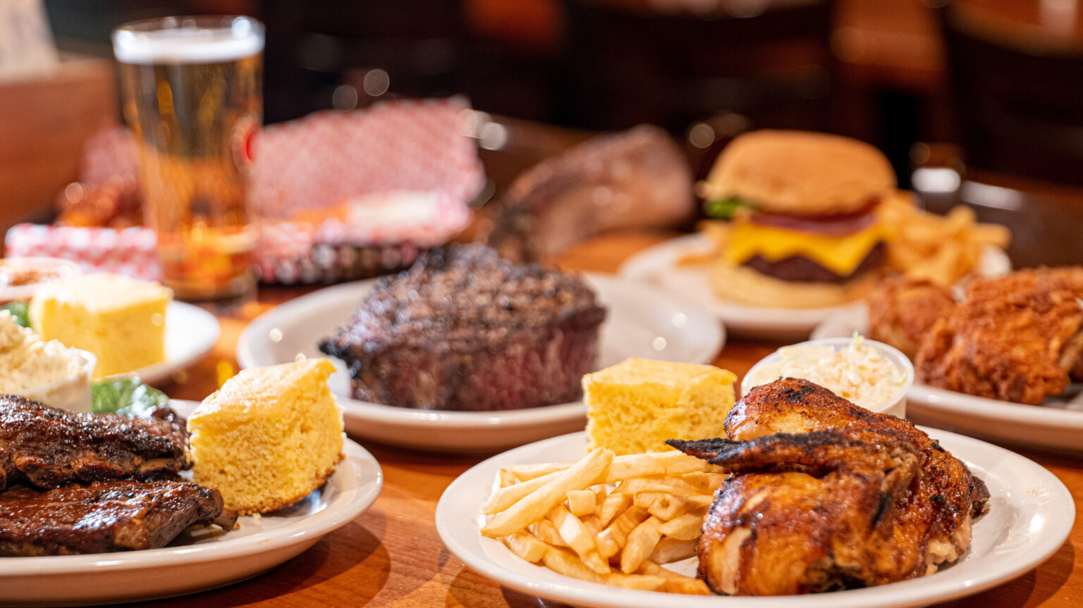 Chicken, steak, ribs, a burger and cornbread on a table at the Chicken Run