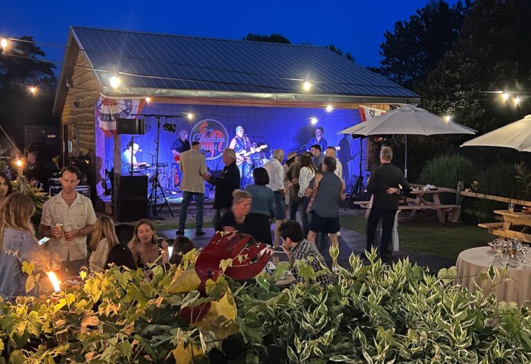Live band on the outdoor stage at the Chicken Run, with guests dancing under string lights